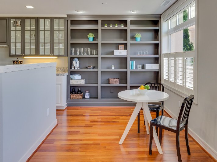 Hardwood floors and grey built in cabinets in a dining area